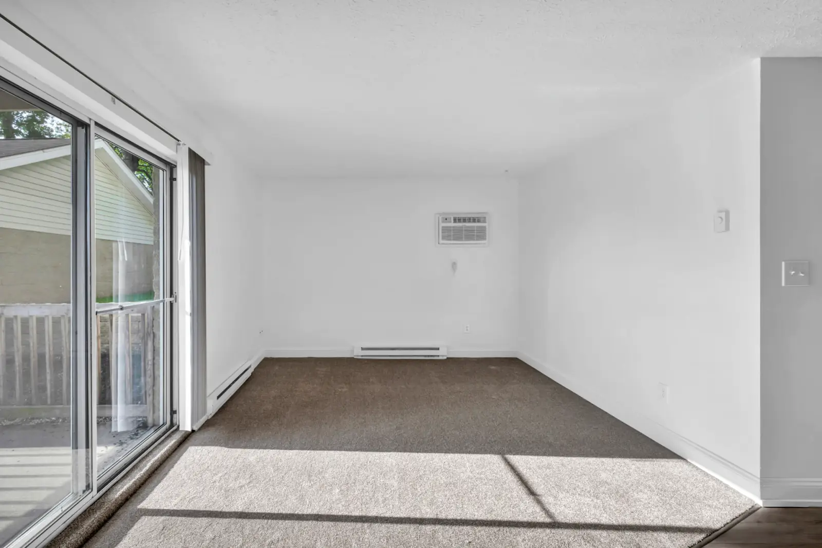 Appartement vide aux murs blancs et grande baie vitrée