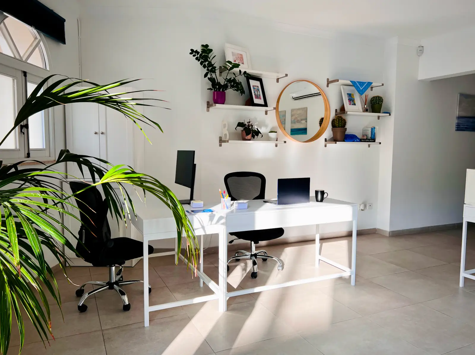 Bureau lumineux avec postes de travail blancs et plantes vertes