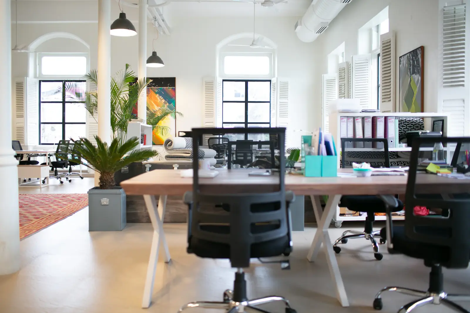 Espace de travail clair avec postes et grandes fenêtres cintrées