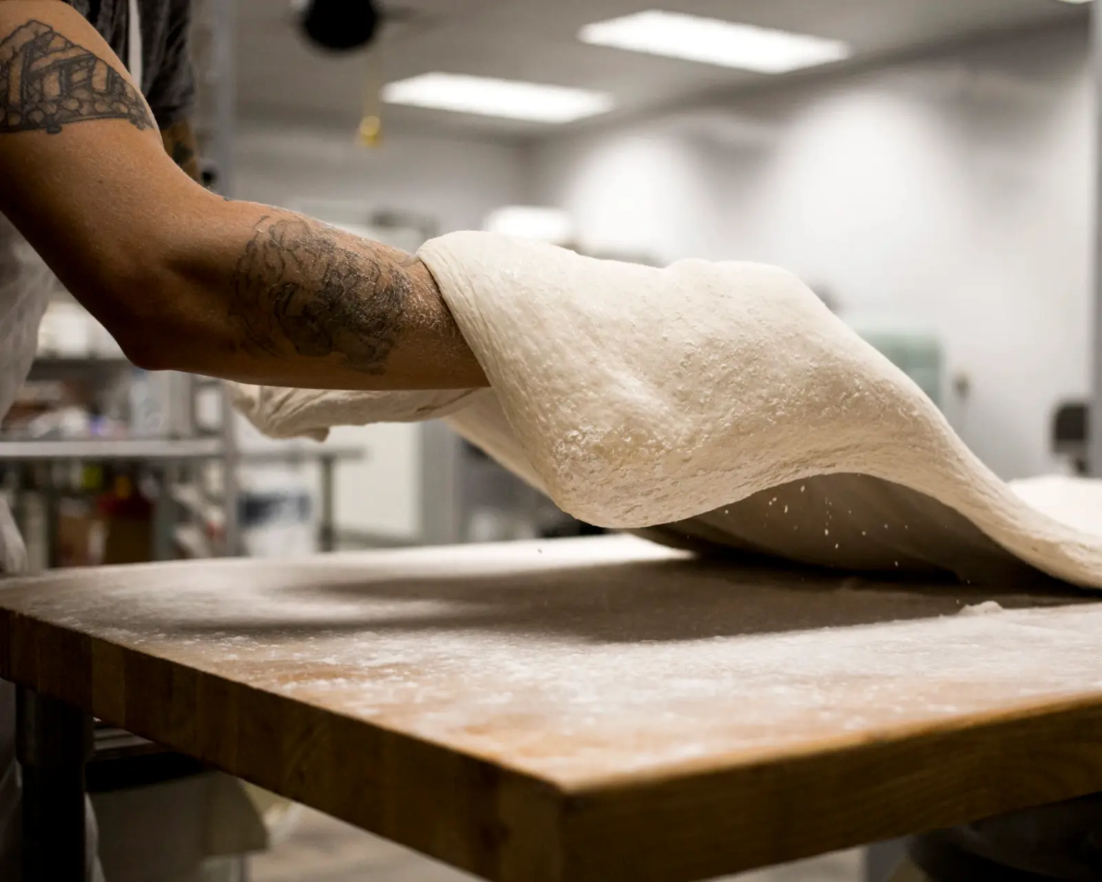Main essuyant un plan de travail en bois avec un chiffon