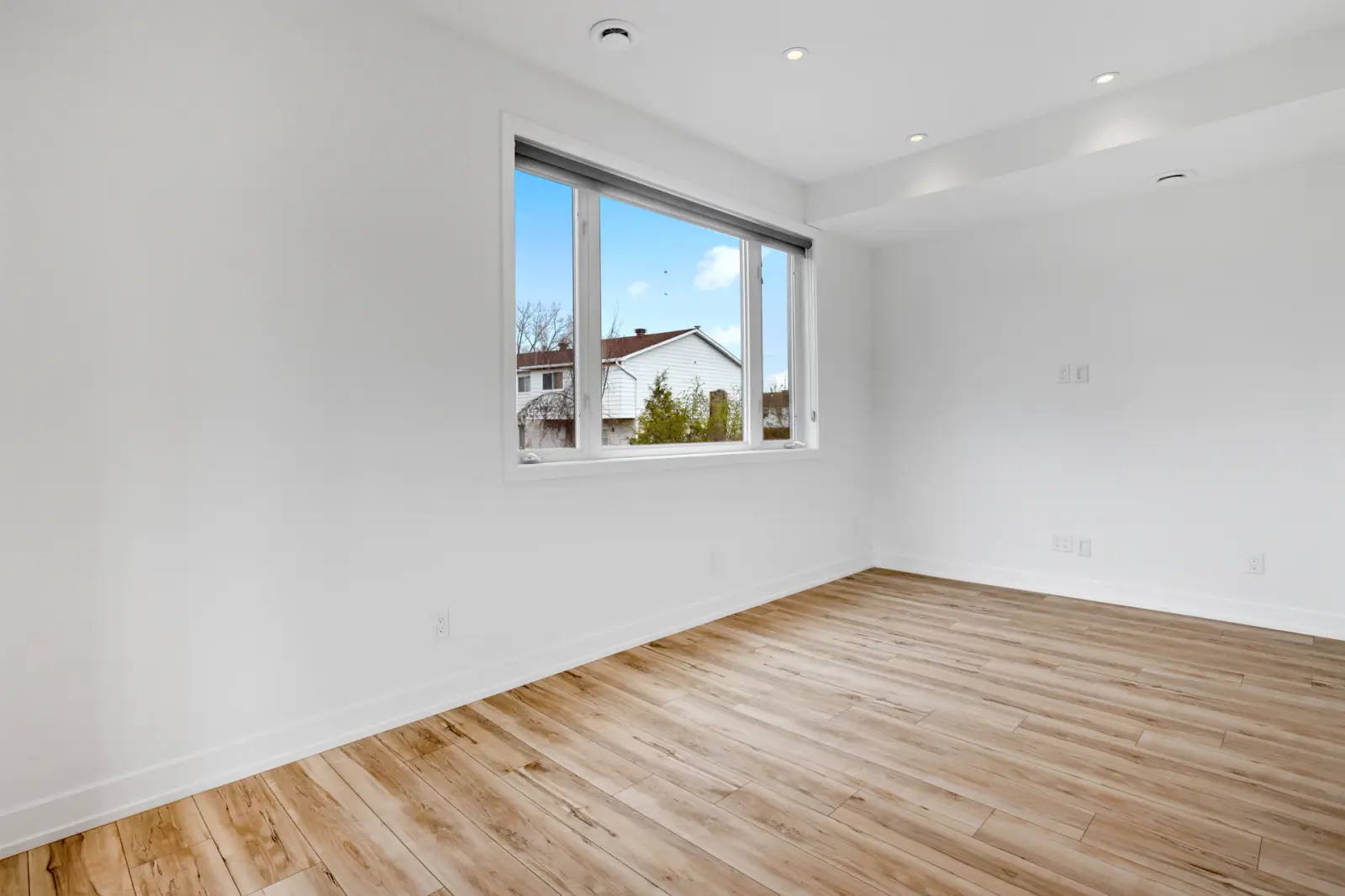 Pièce fraîchement rénovée, murs blancs et parquet clair