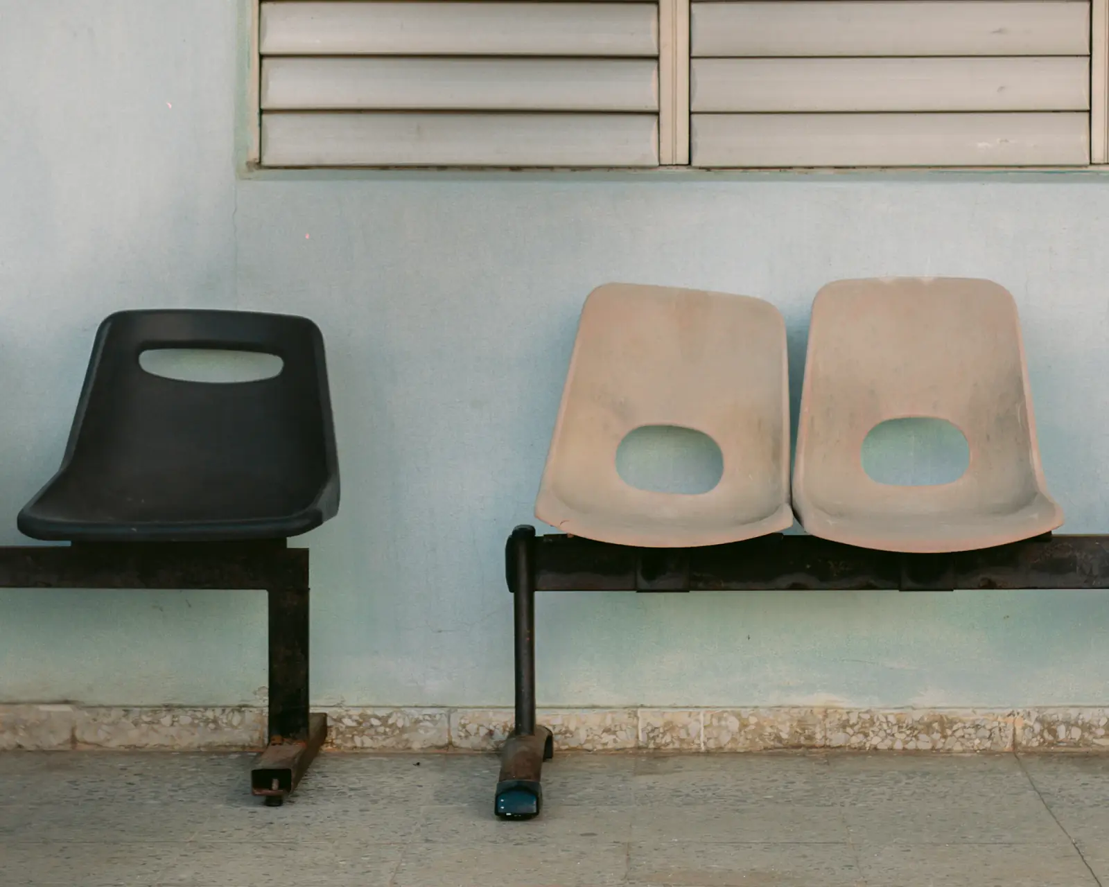 Chaises d'une salle d'attente sobre contre un mur clair