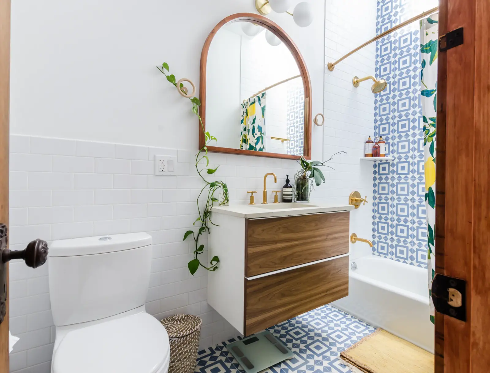 Salle de bains entretenue avec meuble en bois, miroir et plante
