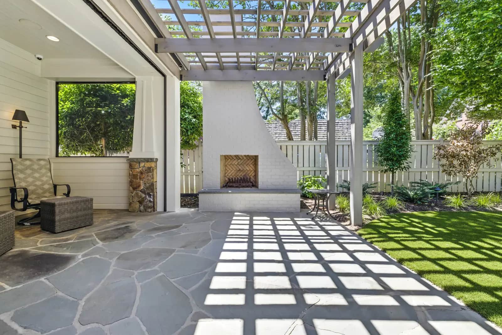 Terrasse dallée sous une pergola, propre et ensoleillée